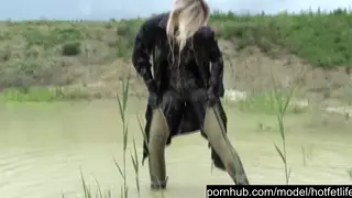 Blonde Woman Bathes in Mud Outdoors