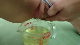Petite Teen Fills a Measuring Cup with Pee