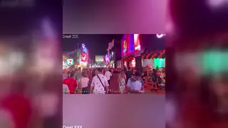 Asian Revelers Dance in Halloween Costumes on a Neon Street