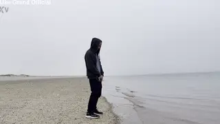 Woman Squats on Beach at Dusk and Lets Stream Flow Free