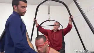 Three Men Share Oral Pleasure at a Desk in Clinical Setting