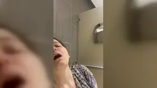 Brunette Masturbates with a Vibrator in a Bathroom Stall While Her Partner Watches