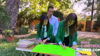 Teacher Uses Uniformed Teens Outdoors at Desk