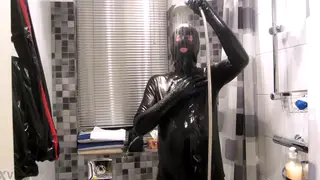 Latex-Clad Figure Enjoys a Cool Shower with Toys