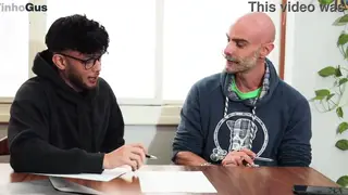Latino Student Learns From European Teacher at Desk