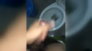 Asian Police Officer Stands in Uniform Inside Bathroom