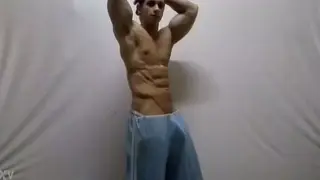 Latino Hunk Flexes Muscular Physique in Gym Setting