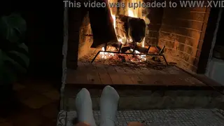 Couple Relaxes by the Fireplace with Foot Play