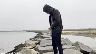 Woman Pisses on Rocky Shore by the Ocean