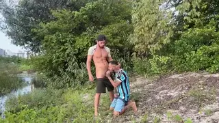 Hiker Kneels for Trail Guide on Scenic Overlook